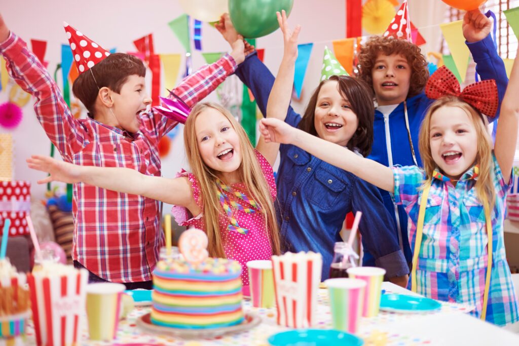 Uma festa infantil com várias crianças felizes comemorando.